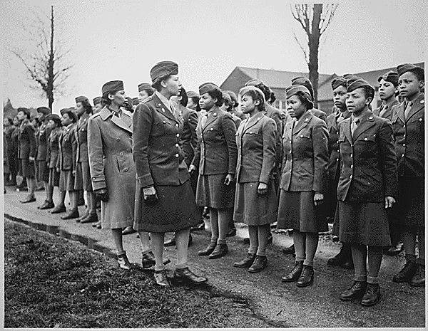 Somewhere in England, Maj. Charity E. Adams,...and Capt. Abbie N. Campbell,...inspect the first contingent of Negro members of the Women's Army Corps assigned to overseas service."